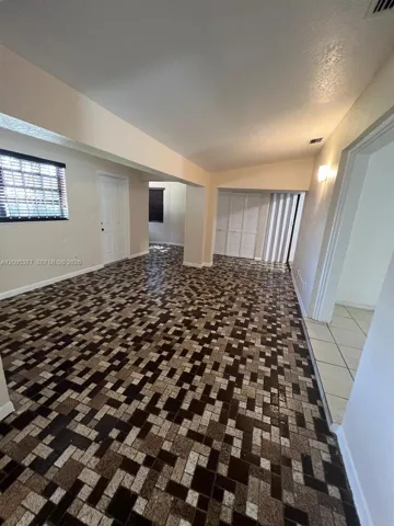 Interior space featuring geometric mosaic-tile flooring, vaulted ceilings, and built-in closet storage with bi-fold doors