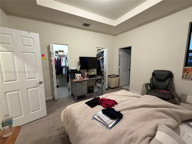 Tray ceiling featuring a recessed center, neutral wall paint, and carpeting