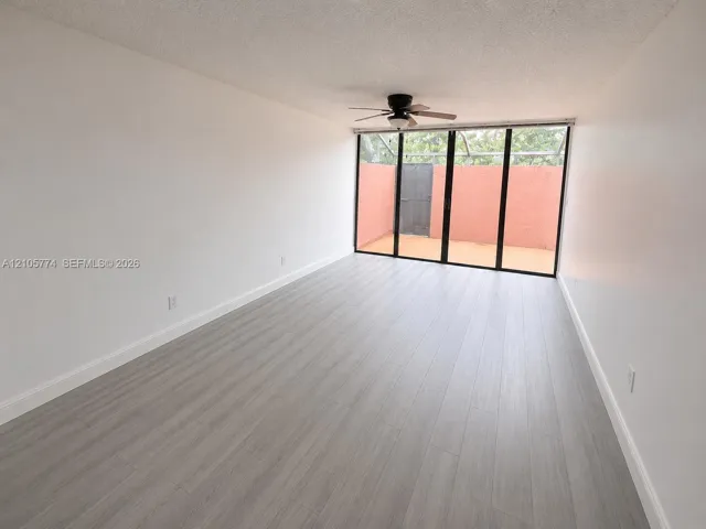 Interior space featuring wood-finish flooring, floor-to-ceiling multi-panel glass doors, and a ceiling-mounted light fixture