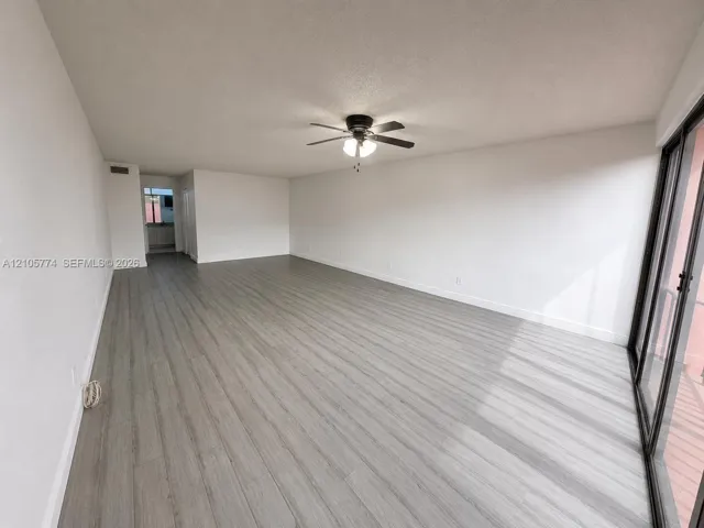 Wood-finish flooring, ceiling fan with integrated light fixture, and sliding glass doors