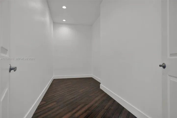 Interior space featuring wood-finish flooring, white walls, and recessed ceiling lighting