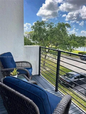Covered balcony featuring dark-toned composite decking and black metal horizontal railing