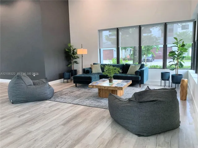 Vaulted ceilings, large-format windows, wood-finish flooring, and a floor-to-ceiling dark accent wall