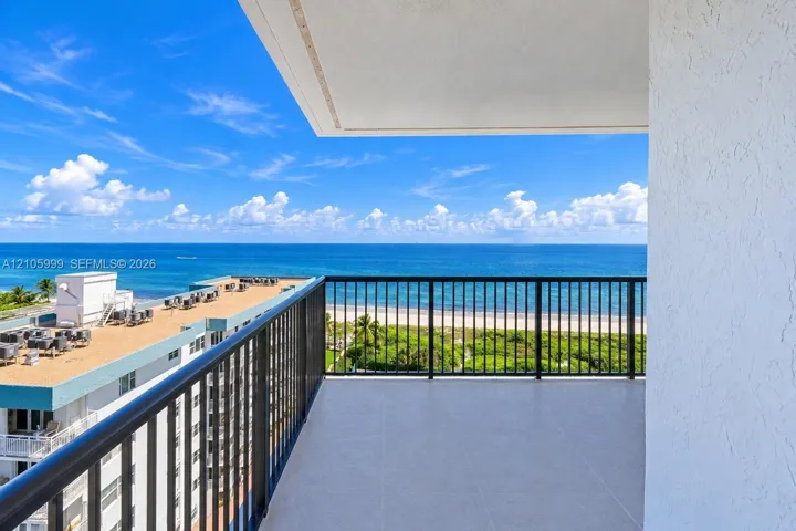 Private balcony featuring tile flooring and black metal railings with an expanse of ocean scenery