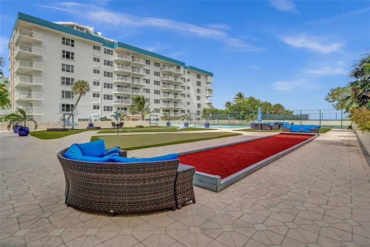 Exterior recreation area featuring a paved terrace, putting green, and bocce ball court
