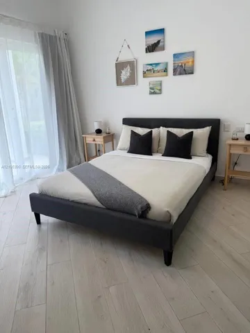 Wood-finish flooring, full-height glass patio door, and neutral wall tones