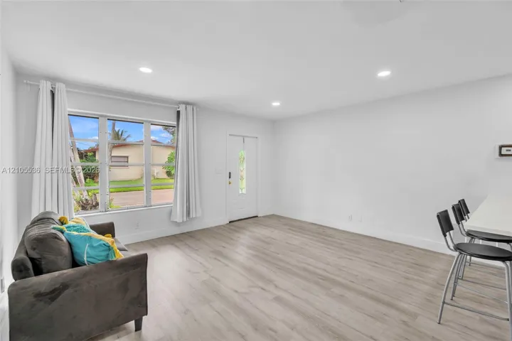 Open living area featuring wood-finish flooring, recessed lighting, and a multi-pane window with exterior exposure