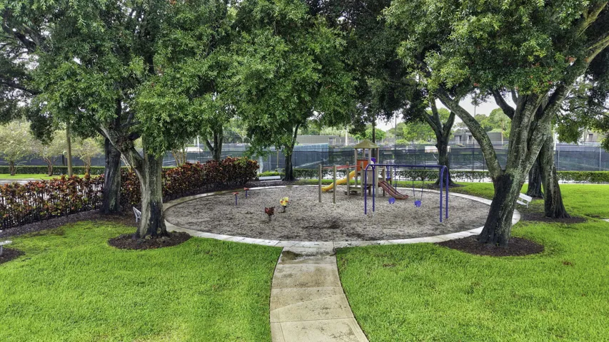 Central recreational area featuring a sand-based play space, swings, and slides