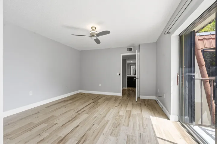 Light wood-finish flooring, neutral wall tones, and ceiling fan with integrated lighting