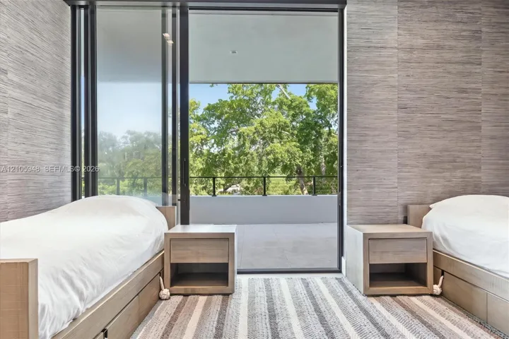 Floor-to-ceiling sliding glass door, private balcony with metal railing, and textured wall coverings