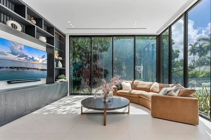 Floor-to-ceiling glass wall, built-in floor-to-ceiling storage cabinetry with open shelving, neutral large-format tile flooring, and recessed ceiling lighting