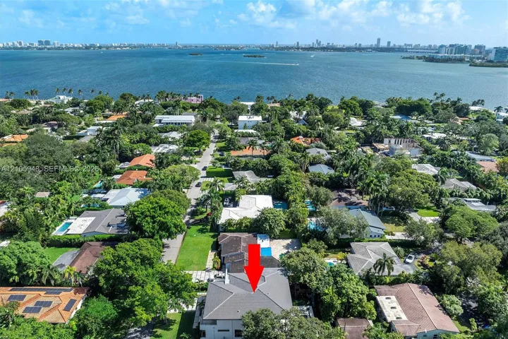 Aerial perspective featuring mature trees, landscaped grounds, and proximity to the waterfront