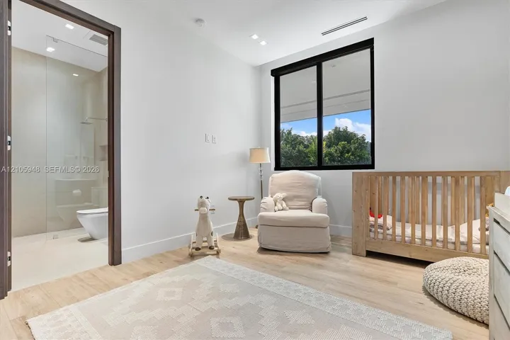 Light-filled room featuring wood-finish flooring, recessed lighting, and a window with a black frame
