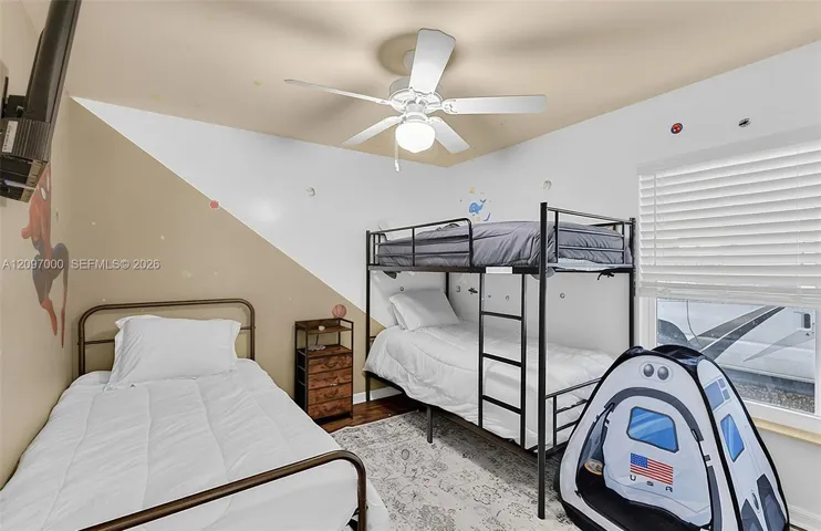 Interior room featuring a ceiling fan, horizontal slat window blinds, and wood-finish flooring