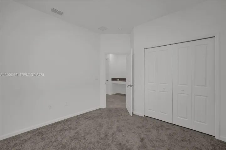 Neutral interior featuring plush wall-to-wall carpeting and a double-door closet with paneled detailing