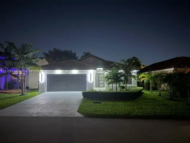 Single-story residence featuring a tile roof, concrete driveway, and attached two-car garage