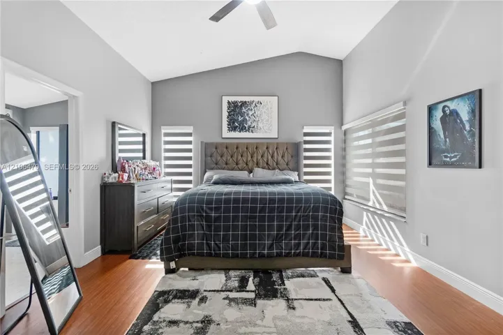 Vaulted ceilings, wood-finish flooring, and multi-paneled windows with integrated blinds