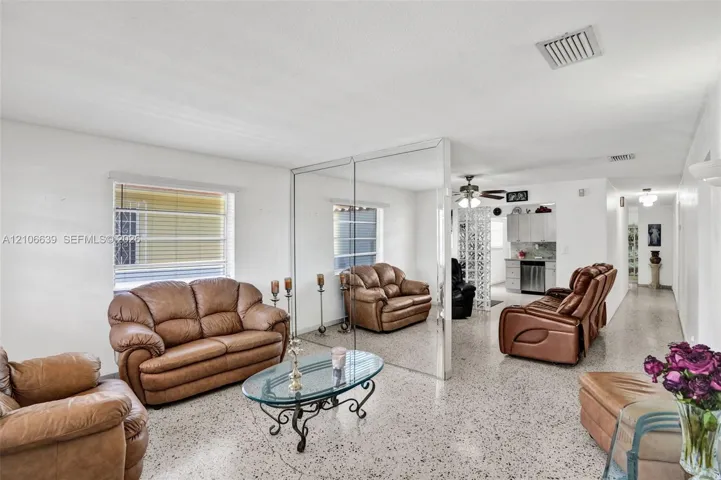 Open-concept interior featuring light-toned terrazzo flooring, expansive floor-to-ceiling wall mirrors, and recessed ceiling lighting