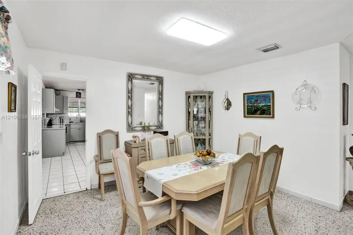 Dining area featuring terrazzo flooring, neutral wall tones, and recessed overhead lighting