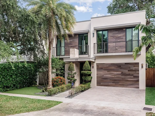 Modern two-story exterior featuring smooth stucco siding, horizontal wood-finish cladding, second-level balconies with metal railings, and an attached multi-car garage