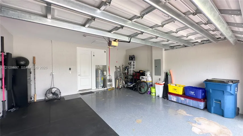Two-car garage featuring epoxy-coated flooring, painted walls, and high-clearance overhead door hardware