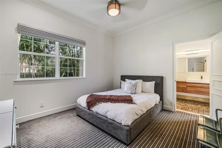 Neutral-toned room featuring a multi-pane window, wall-to-wall striped carpeting, and a ceiling-mounted light fixture