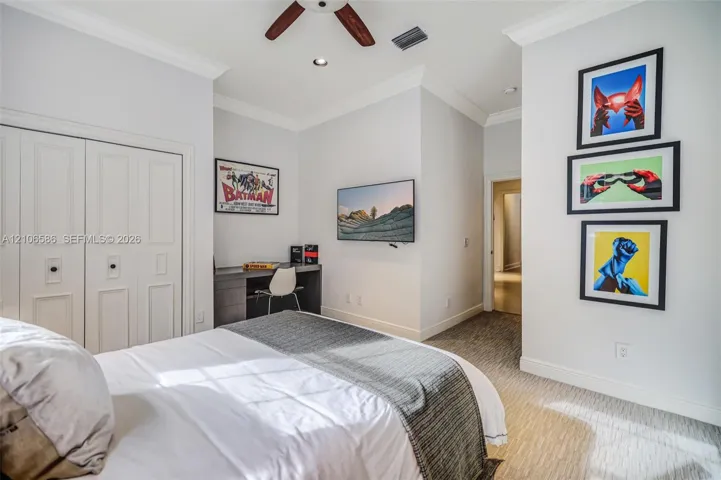 Neutral-toned bedroom featuring recessed lighting, a ceiling fan, carpeted flooring, crown molding, and a built-in desk with​​‌​​​​‌​​‌‌​‌‌​​​‌‌​‌​‌​‌​​​‌​​ cabinetry