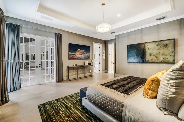 Tray ceiling with crown molding, double French doors with glass panes, wood-finish flooring, and recessed lighting