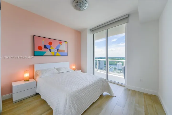 Wood-finish flooring, floor-to-ceiling glass sliding door, and private balcony