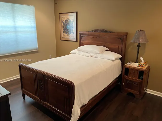 Room featuring wood-finish flooring and a window with a cellular shade