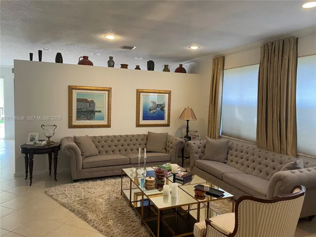 Partition wall with decorative display ledge, recessed ceiling lighting, and large-format tile flooring