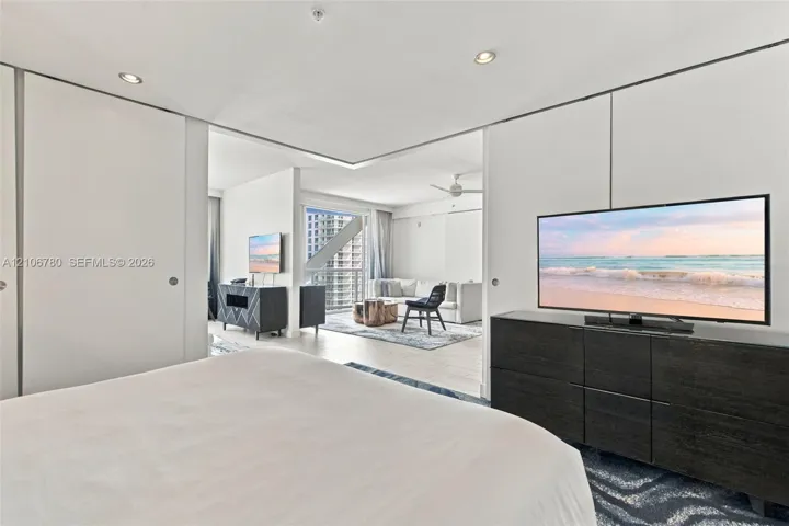 Floor-to-ceiling sliding panels, recessed ceiling lighting, and wood-finish flooring
