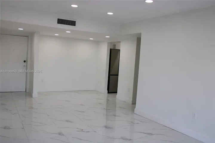 Neutral-toned interior featuring large-format polished tile flooring and recessed LED lighting