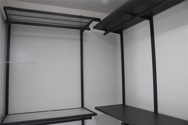 Built-in closet system featuring matte black metal framing, integrated shelving, and wire rack storage components