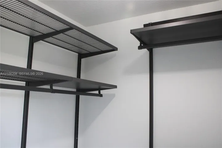 Customizable dark-finish metal shelving system featuring tiered wire racking and integrated hanging rods