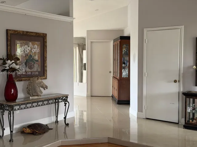 Interior space featuring polished tile flooring, neutral wall tones, recessed lighting, and crisp crown molding