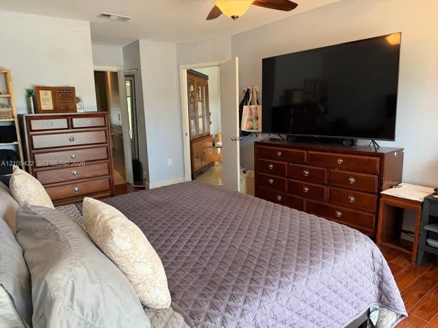 Wood-finish flooring, ceiling fan with integrated lighting, and neutral wall tones