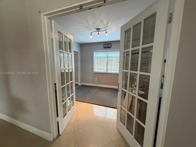 Double French doors featuring multi-pane glass inserts, ceramic tile flooring, and a multi-bulb track lighting fixture