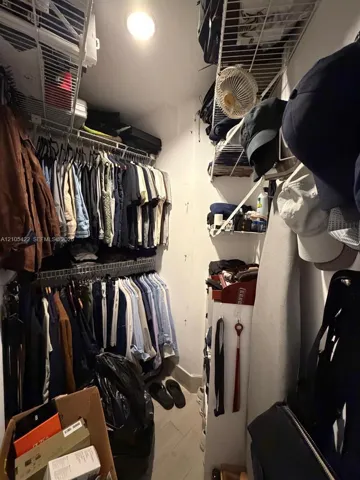Walk-in closet featuring multi-level wire shelving and neutral tile flooring
