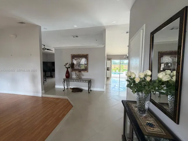 Open floor plan featuring wood-finish flooring, large-format tile flooring, recessed lighting, and crown molding