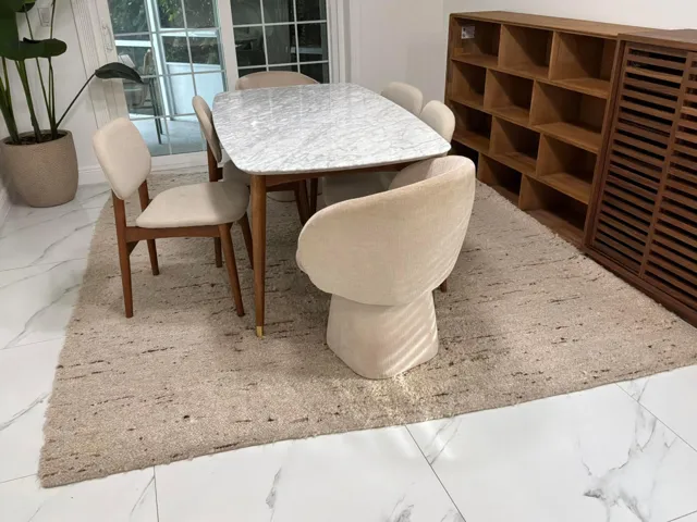 Large-format polished stone flooring with neutral veining featuring sliding glass doors with a white frame