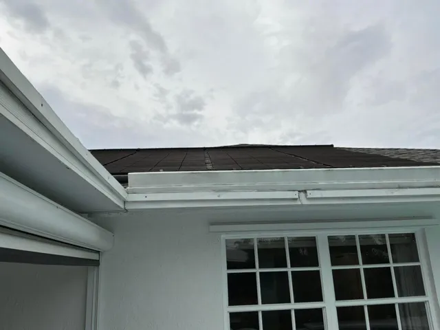 Exterior featuring solar panel array, white stucco finish, and multi-pane grid windows