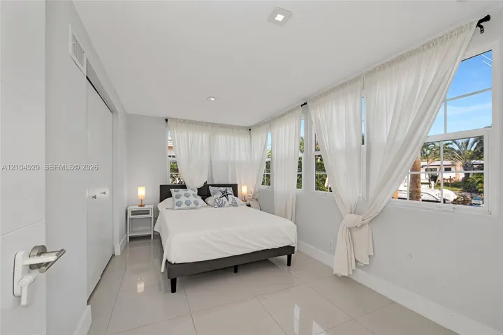 Bright interior space featuring polished tile flooring, recessed lighting, and multiple windows with muntin detailing
