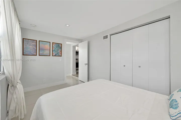 Interior room featuring large-format tile flooring, recessed lighting, and a double-door closet with polished hardware