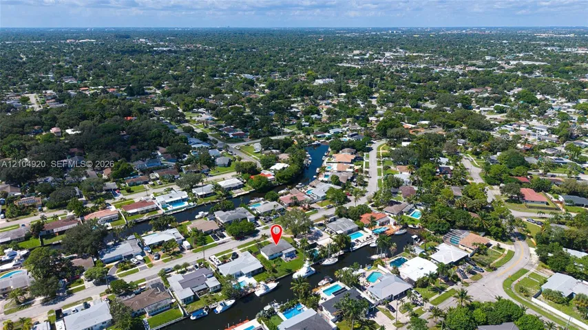 Aerial perspective of the waterfront property featuring direct canal access and residential street positioning
