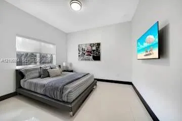 Neutral interior featuring high-gloss tile flooring, smooth wall finish, recessed ceiling lighting, and a window with a retractable roller shade