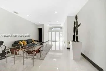 Open interior space featuring high ceilings, polished tile flooring, recessed lighting, and expansive glass-paned double doors