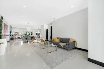 Open-concept living space featuring high ceilings, recessed lighting, and polished stone flooring throughout