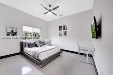 Neutral-toned interior featuring high ceilings, a ceiling fan with integrated lighting, polished flooring, and a large window