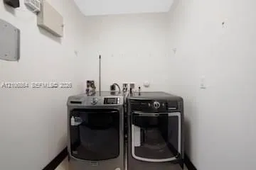 Laundry area featuring dark metallic-finish washer and dryer units with digital control panels and clear-view glass doors